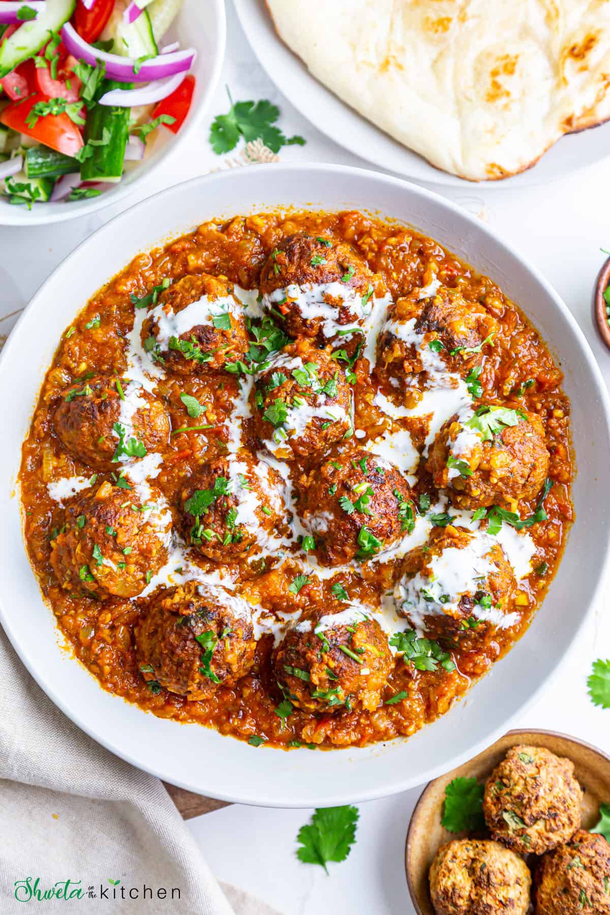Lauki Kofta curry served in a bowl drizzled with cream and garnished with cilantro