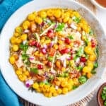 Top view of ragda chaat in white bowl garnished with chutney and toppings