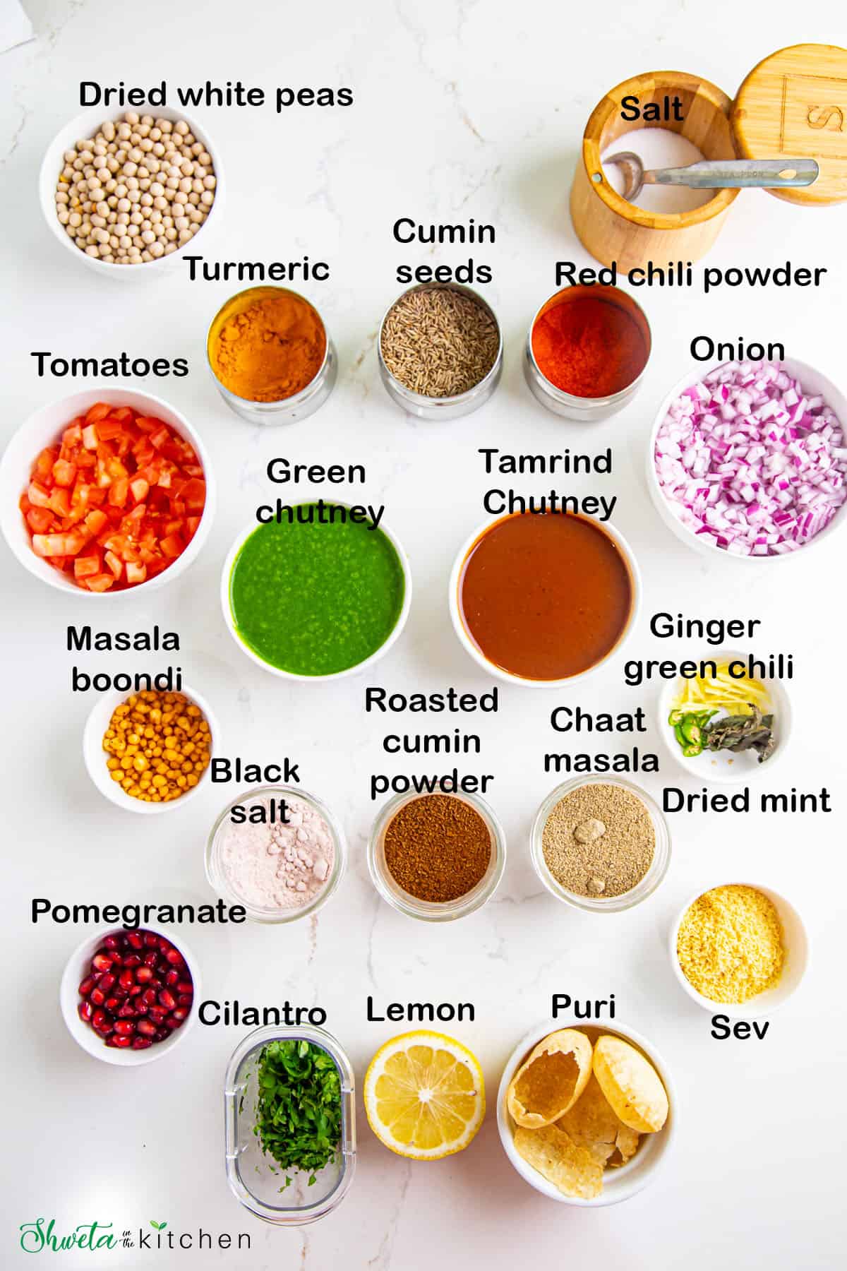 Ingredients for Ragda chaat placed in bowls on white surface