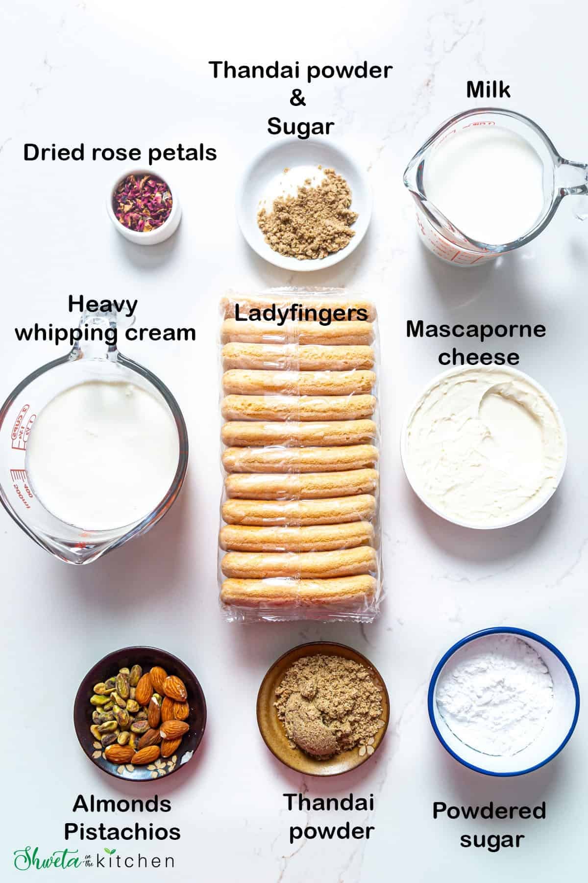Top view of the ingredients for thandai tiramisu placed on white surface