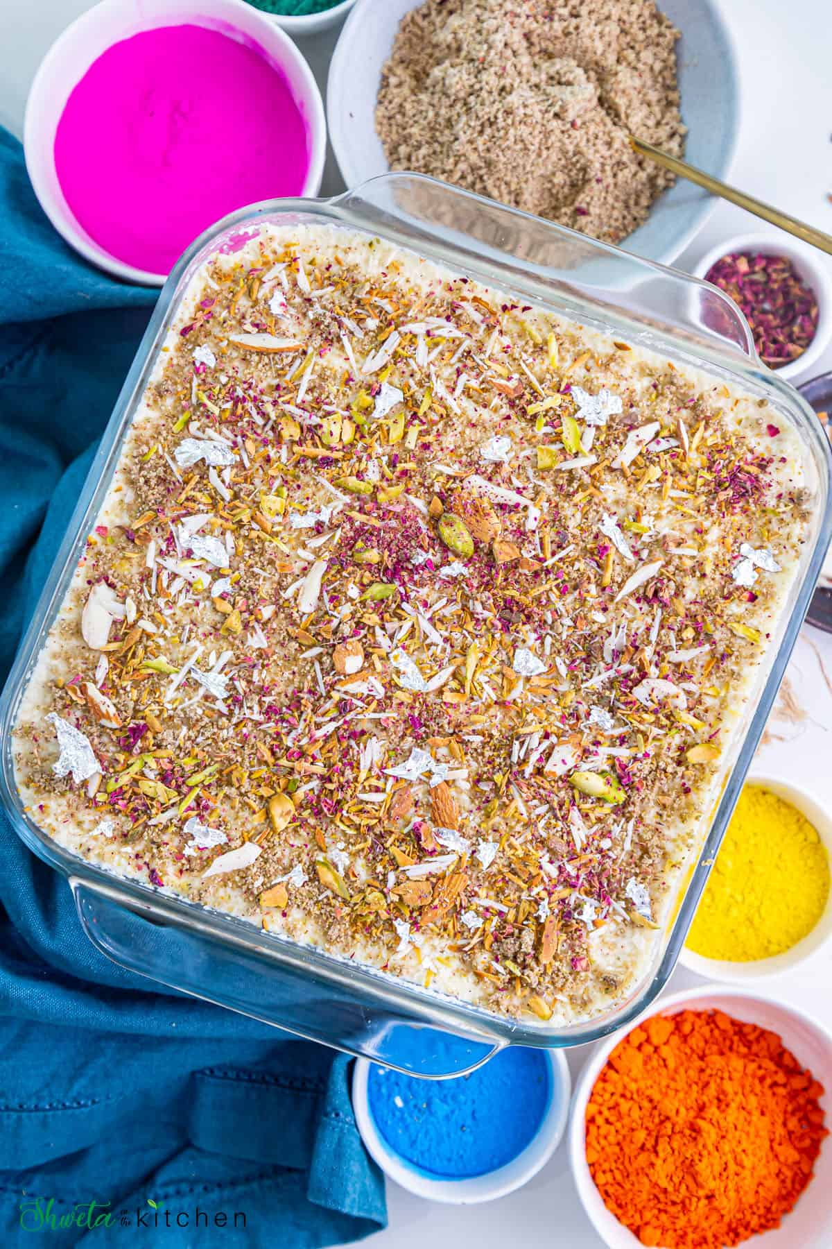 Top view thandai tiramisu with bowls of holi colors on the side